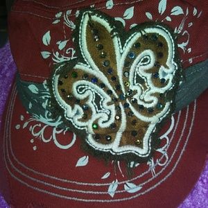 Red  denim fitted hat with fleur-de-lis on it